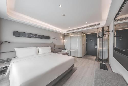 杭州杭州下沙轻居酒店的卧室配有一张白色的大床和一张桌子