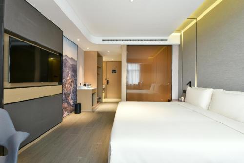 北京北京望京798艺术区亚朵酒店的酒店客房设有一张大床和一台电视。