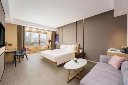 大连大连星海广场亚朵S酒店的酒店客房,配有床和沙发