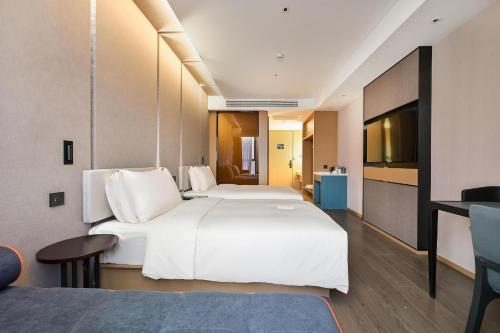 昆明昆明长水国际机场亚朵酒店的酒店客房设有两张床和电视。