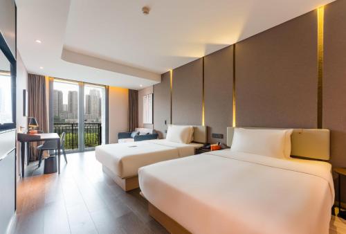 重庆重庆天地网易云音乐亚朵酒店的酒店客房配有两张床和一张书桌