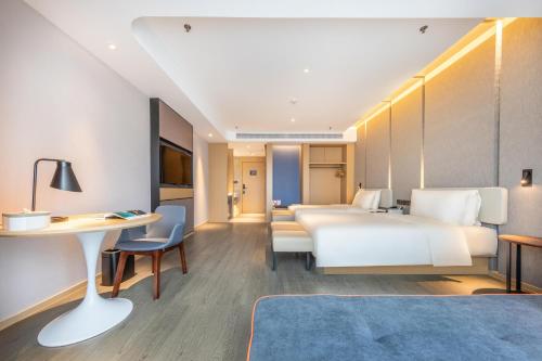 昆明昆明南悦城亚朵酒店的配有一张床和一张书桌的酒店客房