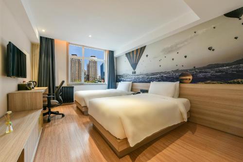 北京北京建国门CBD亚朵轻居酒店的酒店客房配有两张床和一张书桌
