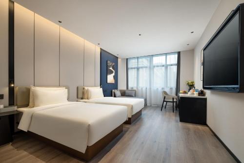 杭州杭州新天地中大银泰亚朵酒店的双床间 - 带2张床 - 带平面电视的酒店客房