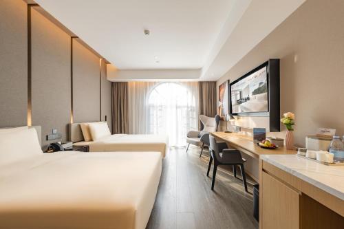 上海上海浦东机场川沙地铁站亚朵酒店的酒店客房配有两张床和一张书桌