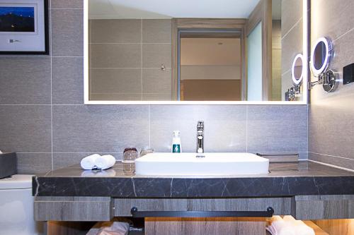 秦皇岛秦皇岛火车站迎宾路亚朵酒店的一间带水槽和镜子的浴室