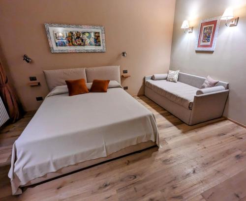 Tovo San GiacomoAgriturismo Peq Agri-Resort Tovo的一间卧室配有一张大床和一张沙发