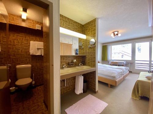 帕尔潘阿尔皮纳巴班酒店的一间带一张床和一个水槽的浴室和一间带卫生间的浴室