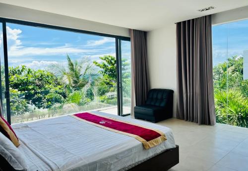 头顿D6 Aria Resort的一间卧室配有一张床、一把椅子和一个大窗户