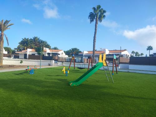 圣巴托洛梅Bungalow 1 Maspalomas Golf con piscina y jardín的草地上带滑梯的游乐场