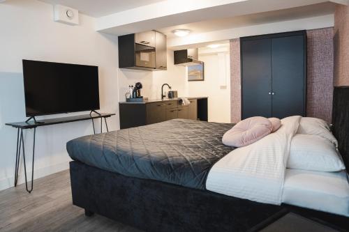 迪温特The Residence Deventer的一间卧室配有一张床和一台平面电视