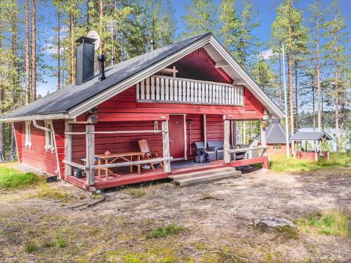 Raanujärvi皮尔欧拉度假屋的红色小屋,在树林里设有门廊