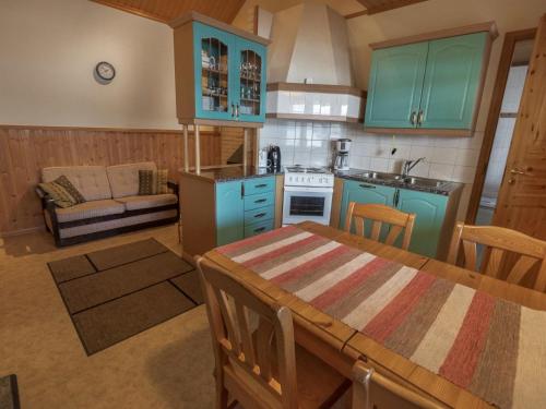 Matildedal萨图里纳度假屋的一间厨房,内设蓝色橱柜和一张桌子