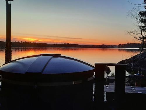 KosulaHoliday Home Lomasuvas by Interhome的日落时分坐在湖岸上的船