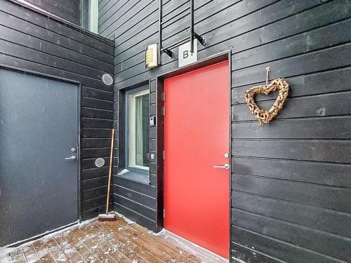 HyrynsalmiHoliday Home Skivillas 61 ukkohalla - b1 by Interhome的红门,在黑色墙上挂着心花环