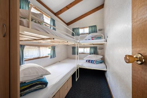 布赖特布莱特住宿公园酒店的一间小卧室,位于一个小房子内,配有双层床