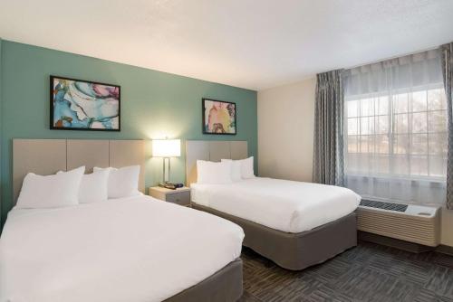 格林斯伯勒MainStay Suites Greensboro的酒店客房设有两张床和窗户。
