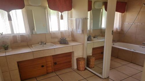 FrankfortFrankfort Guesthouse的浴室配有两个盥洗盆、浴缸和浴缸。