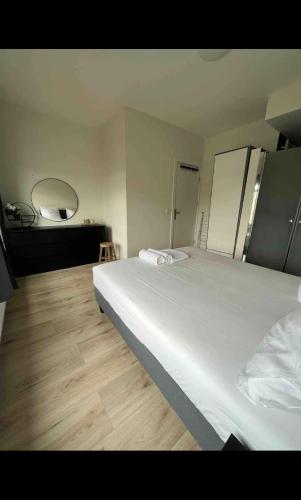 海牙Cosy Apartment in the Hague!的卧室配有一张白色大床和镜子