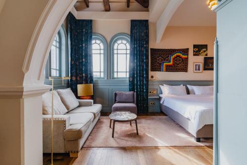 阿姆斯特丹Hotel Mercier的一间卧室配有一张床、一张沙发和一张桌子
