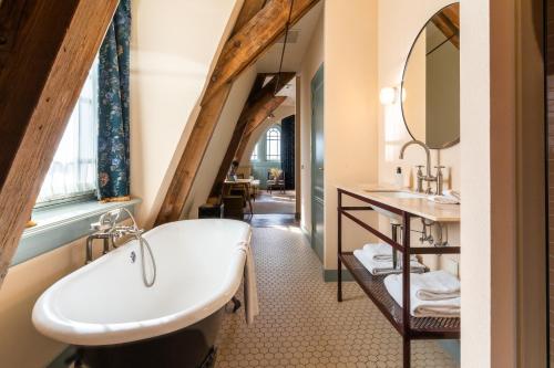 阿姆斯特丹Hotel Mercier的阁楼浴室设有水槽和浴缸。