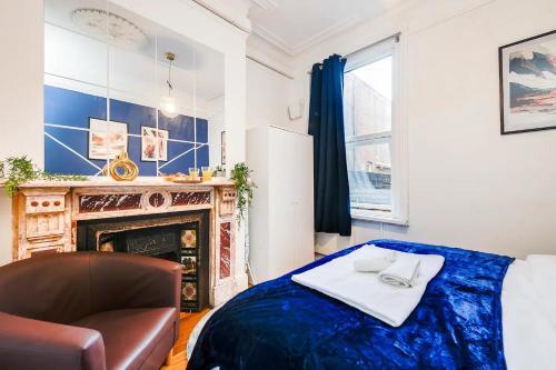 南安普敦Southampton City Centre 1 Bed Apartment的一间卧室配有一张床、一把椅子和一个壁炉