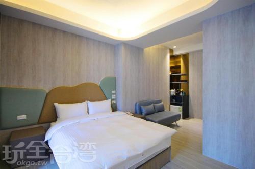 礁溪礁溪玥湯溫泉旅店的一间卧室配有一张大床和一把椅子
