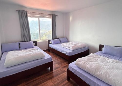 博卡拉Dhikidada Resort的客房设有两张床和窗户。