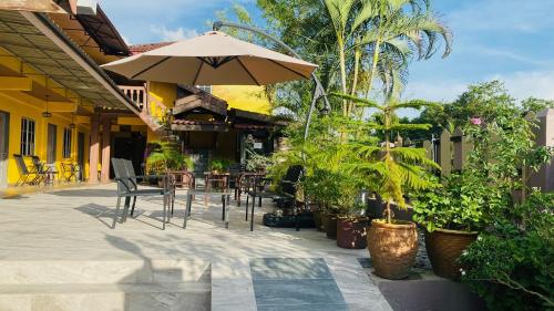 瓜埠珍珠汽车旅馆的一个带遮阳伞、椅子和植物的庭院