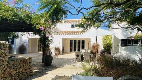 圣克莱蒙Holiday Home Casa MADORIA的白色的房子,配有桌子和雨伞