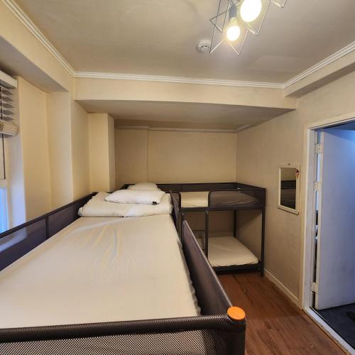 首尔Joy Guesthouse的客房设有两张床和一张双层床。