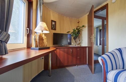 欧巴德伍斯图Hotelschiff Stinne的客房设有一张带电视和台灯的书桌。