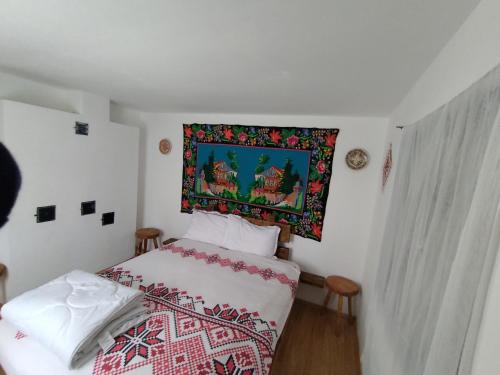 RîşcaCăsuța de la râu的卧室配有一张挂在墙上的床铺