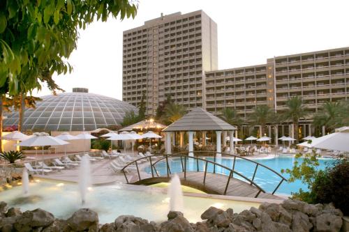 依克希亚洛德斯宫殿酒店的一个带遮阳伞的游泳池和酒店