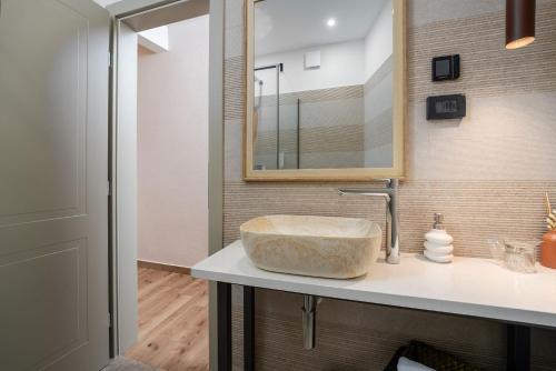 斯维特温斯纳特Della Croce Bed&Breakfast的一间带石制水槽和镜子的浴室