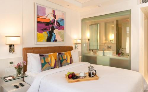 新德里阿斯坦萨诺瓦门廊酒店的一间卧室配有一张床,上面有水果盘