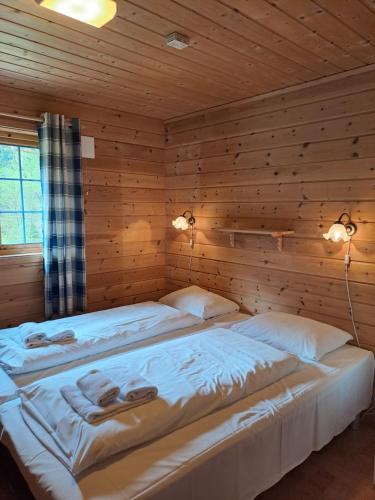 Klakegg斯塔德伦海特格兰德酒店的木墙客房的两张床