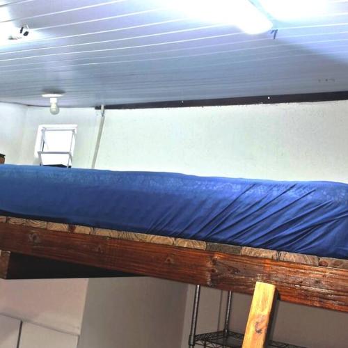 弗洛里亚诺波利斯Tiny House da Tata的蓝色床单的客房内的双层床