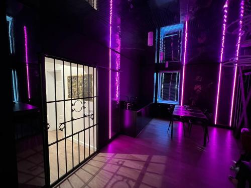 琴斯托霍瓦BDSM Apartament Luxxx gorące serce Częstochowy - ADULTS ONLY的墙上有紫色灯和门的房间