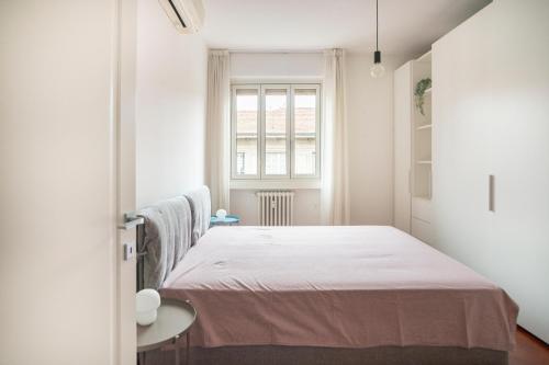 米兰Isola Milano apartment的一间卧室设有一张床和一个窗口