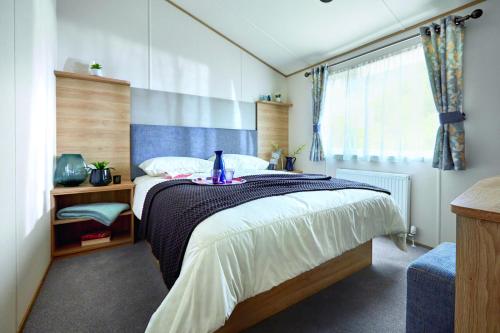纽基Newperran Holiday Park的一间卧室设有一张大床和一个窗户。