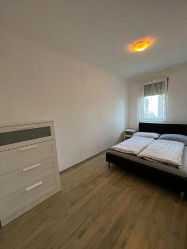 塞格德Kristály Apartman的一间卧室配有一张床和一个梳妆台