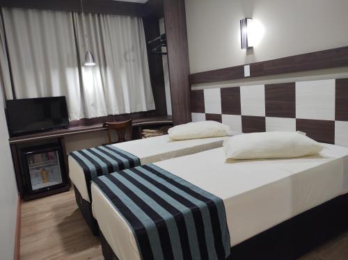 弗朗西斯科贝尔特朗Hotel Maestro Express的酒店客房设有两张床和电视。