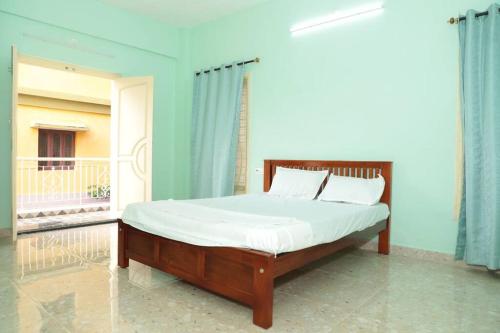 蓬蒂切里Soundar villa的一间卧室配有一张带白色床罩的床