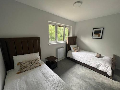 格拉斯哥Ideal 2 Bedroom Glasgow Home的一间卧室设有两张床和窗户。