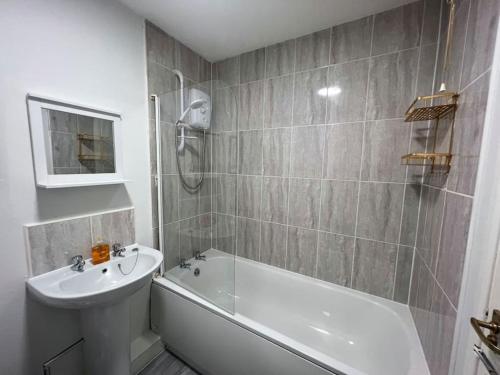 格拉斯哥Ideal 2 Bedroom Glasgow Home的浴室配有白色浴缸、水槽和淋浴。