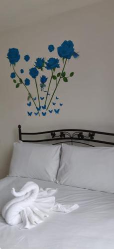 伦敦Richmond London 2 bed room Appartement的卧室配有一张挂着蓝色鲜花的床。