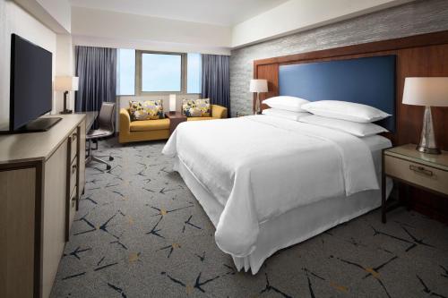 洛杉矶Sheraton Gateway Los Angeles Hotel的酒店客房设有一张大床和一台电视。