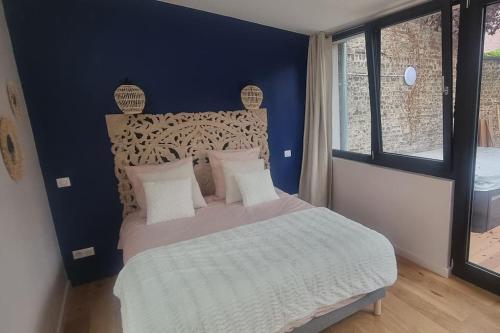 里尔Les Spas du Sébasto的一间卧室设有一张蓝色墙壁的大床