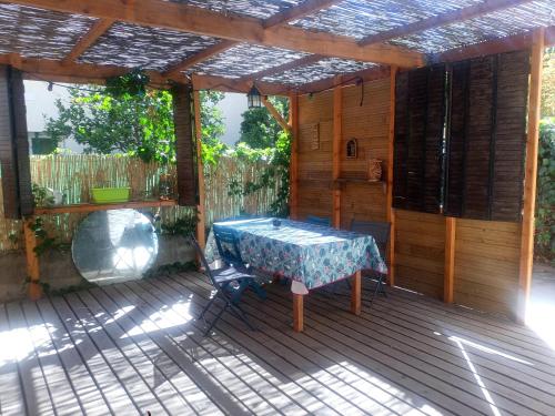 佩皮尼昂Studio d'aqui et d'ailleurs的木制甲板上配有桌子的庭院